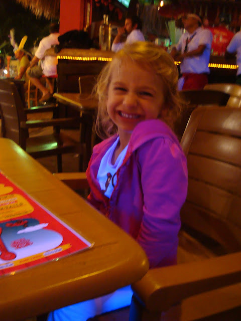 Young girl sitting at table inside Señor Frogs