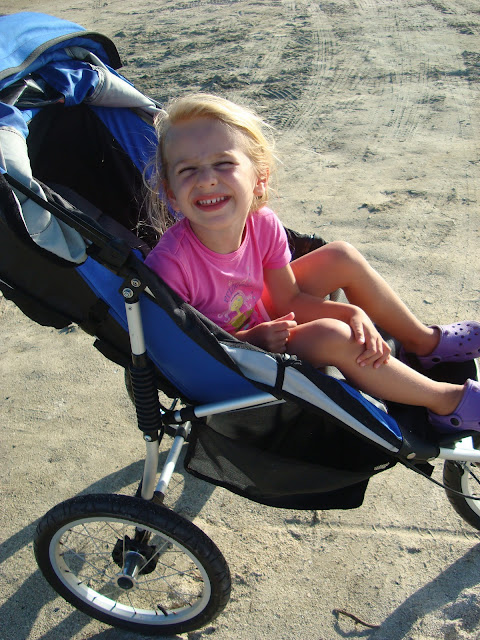 Young girl in stroller leaning over smiling