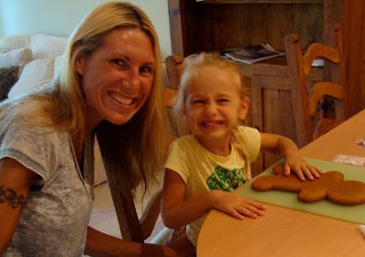 Woman and young girl at table with gingerbread man smiling