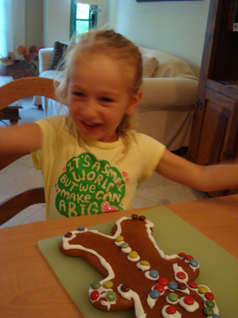 Gingerbread man in front of young girl with arms outstretched 