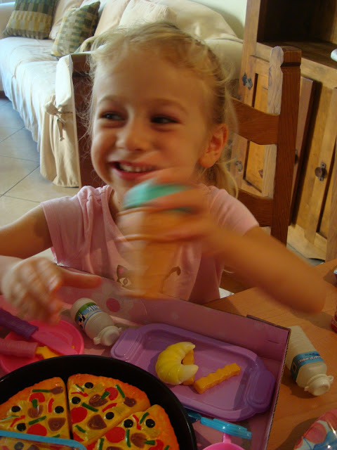 Young girl sitting at table playing with toys