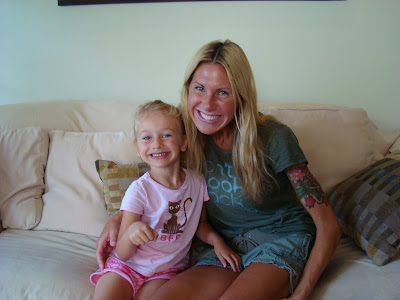 Woman hugging young girl on couch smiling