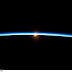 La fina atmósfera terrestre y un incipiente Sol fotografiados desde la ISS