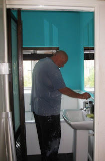 Decorator adding finishing touches to the bathroom paint