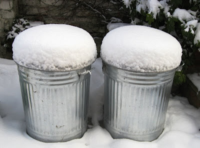 Snow piled on top of two metal bins