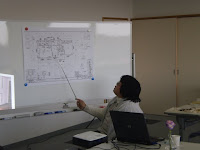 設計図を示しながらお話しする藤田さん