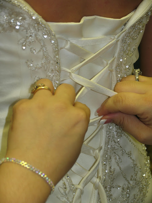 Her sister lacing her dress