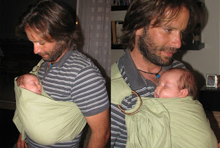 Το νεογέννητο μωράκι, ξαπλωμένο στην αγκαλιά του μπαμπά της, με ring sling.