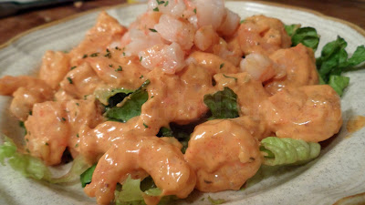 Cold cooked shrimp are dressed up with a tangy remoulade sauce and served over a bed of lettuce.