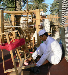 Men work at a loom in Doha's heritage village