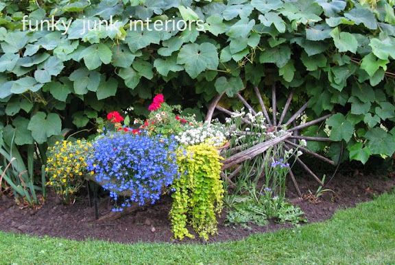 Learn how this wheelbarrow was turned into a beautiful planter garden feature! Click for many other gardening tips also included! #gardening #gardentips #flowers