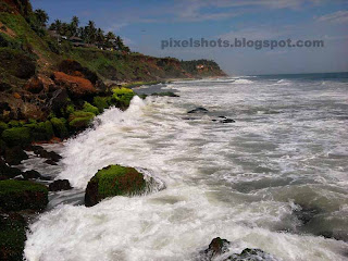 rocks in kerala beaches,sedimentary beach rocks in varkala-trivandrum-kerala-india,indian beach photos,monsson time rough sea waves hitting the beach rocks