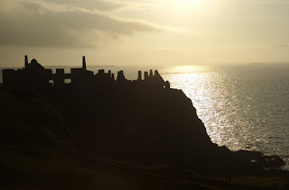 The ruins of Dunluce Castle stand guard over the sea near Portrush at sunset
