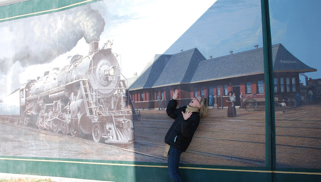 Wiman pretending to get hit my a train in front of a mural