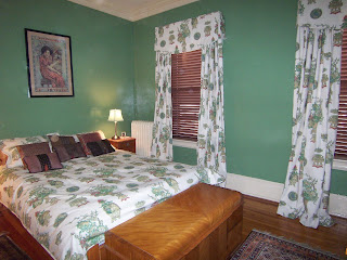 Asian-themed bedroom with green lacquer walls and Asian-themed bedroom drapes and wooden blinds