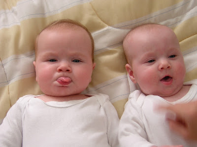 twin babies with tongue sticking out