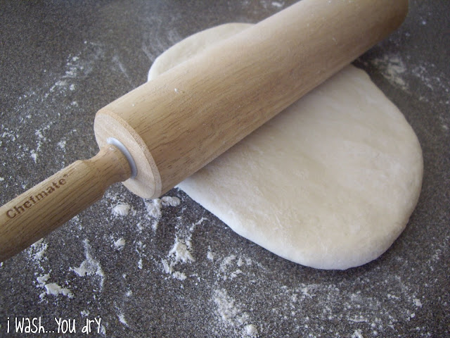 A roller rolling pizza dough out. 