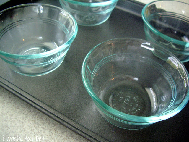 Four small glass desert dishes in a pan. 