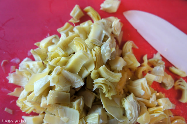 A close up of chopped artichokes on cutting board.