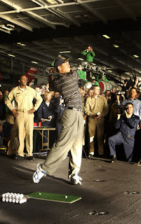 Sailors watch professional golfer Tiger Woods hit a few golf balls during a demonstration in the hanger bay of the nuclear powered aircraft carrier USS George Washington (CVN 73). U.S. Navy photo by Photographer's Mate 1st Class Brien Aho. (RELEASED)