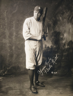 Babe Ruth in baseball uniform holding baseball bat