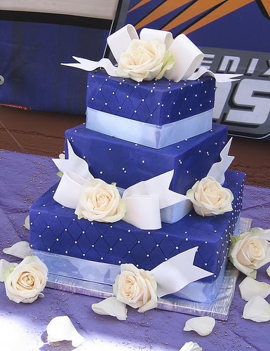 Deep rich purple square wedding cake decorated with white calla lilies