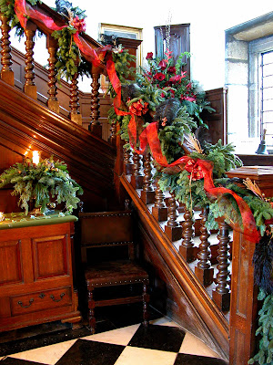 The entrance hall festooned with foliage swags and fresh flower arrangements