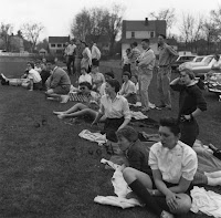 A photograph of several men and women seated and standing together on a lawn.