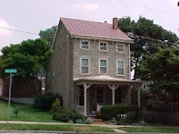 Red traditional standing seam tin roof on stone house