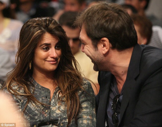 Loved-up Penelope Cruz takes her romance courtside as she smooches with