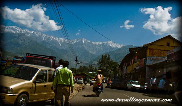 Glimpses of Palampur Town with Travelling Camera: Posted by VJ Sharma @ www.travellingcamera.com : Palampur, a dream place to live... Really, I have been to Palampur many times and more I visit this place, more I fell in love with this place... Town with wonderful views of snow covered Dhauladhar Mountains, Naturally rich has most of the modern facilities available...Here is a view from Tea Gardens near Neugal Cafe...Just entered into Palampur Town: From this Photograph you can make an idea that mountains around Palapur are clearly visible from most of the areas in this town... Weather in this town is amazing... Its not as crowded as Shimla and is comparatively rich in terms of basic facilities like Water, Light etc..A Photograph shot from moving car in the middle of Palampur Market... You can also see snow covered hills from here also ;-) .. Palampur Market is lovely place to spend your evenings..Most of the telecommunication service providers are there in Palampur and its not only the case for telecom services, but other types are services are also available with broad range of varieties. Palampur is very well connected through Bus, Train and there is also an Airport in Kangra....More clear view of Dhauladar Mountains from Neugal Khad....Palampur was a part of the local Sikh Kingdom before it came under the British raj. It was one of the leading hill states and was once a part of the Jalandhar kingdom. There are countless water streams, tea gardens and rice paddies. The town of Palampur came into being when Dr. Jameson who was Superintendent of Botanical Gardens and introduced the tea bush from Almora in 1850. The bush thrived and so did the town which became a focus of the European tea estate owners. Since then the Kangra tea of Palampur has been known internationally.