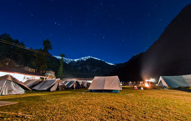 Kullu Sarahan - A Wonderful place for camping on a lush green valley in the middle of snow covered hills of Shrikhand Mountain Ranges : Posted by VJ SHARMA on www.travellingcamera.com : Sometimes when I am asleep, a faraway call beckons me to it. It is the mountains calling. I know. How can I not know? The spirit of the mountains dwells in me and is an inseparable part of my being. And every so often, I have that urge to pack my things and go back to the place where I belong - to the beautiful hills of Himachal.Here is a photograph of surrounding hills and Moon going down in early morning @ Kullu Sarahan, Himachal Pradesh... We had a one day trek to the nearest snow covered peak and had great fun there .... Whole trek was full of waterfalls, small water streams and can't explain the natural beauty in words... One has to be there to feel the freshness of the place... Even I was imagining about a video camera which can also capture the real time freshness of the place.. The way wind flows and sudden welcome by clouds & rains... Hope someone is listening to my wish and produce such a product so that Travelling Camera can share the real view of the place...Here is a photograph of main temple which was in the middle of habitat region of Sarahan Village... Very colorful with lot of artworks and unique architecture... When I was there witnessing the scene of snow covered hills behind the temple, the only thing came into my mind was 
