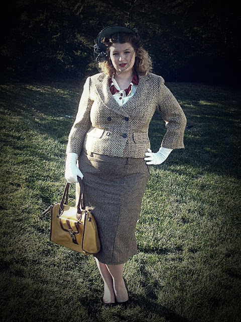 1940s style suit and hat with veil and a mustard handbag