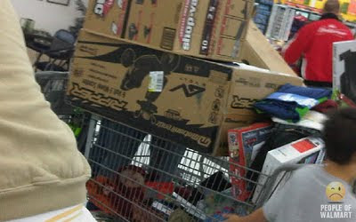 baby in shopping cart under a lot of big walmart purchases