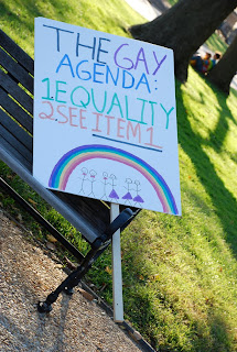 protest sign with rainbow that says The Gay Agenda: 1. Equality 2. See Item 1