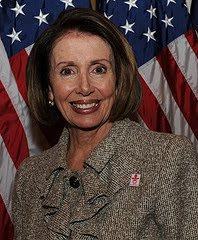 a sinister looking Nancy Pelosi posing in front of an American flag