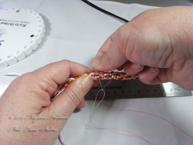 Kumihimo basics: tie off the braid before removing the cords from the disk to prevent it from unravelling.