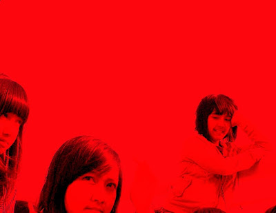 Three girls posing in the red background