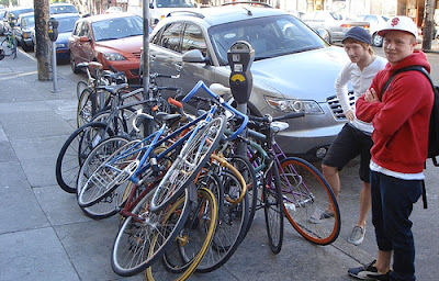 Image of bikes piled high on street, locked to one pole