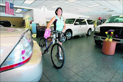 Peggy Strickland walks her bike through the showroom at the Lakeland Automall.