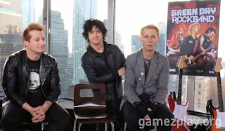 green day sitting at skysraper window with rock band poster behind
