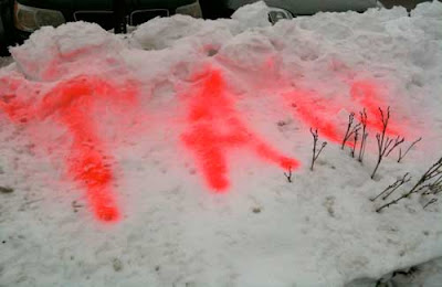 Red spray-painted word TAN on a snowbank