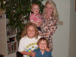 Photo of blond smiling woman with three children