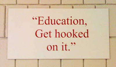 White sign with red letters reading quote Education-Get hooked on it. unquote