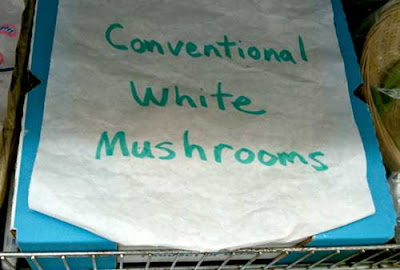 Hand-written sign on box in produce section, White conventional mushrooms