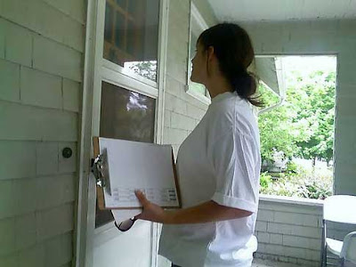 Woman ringing a doorbell, holding a clipboard