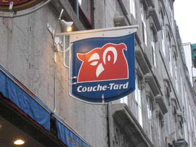 Blue and red sign with a stylized owl symbol and the name Couce-Tard