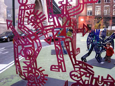Kokopelli-like metal cut-out sculptures in a range of bright colors