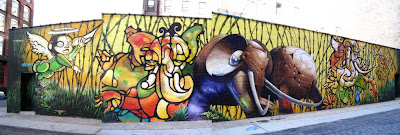 Wide painted mural of elephants in a range of style from manga to mechanistic