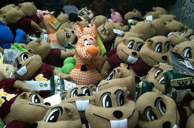 A single orange and white gingham Scooby Doo surrounded by a sea of Goldie Gopher dolls